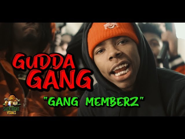 Gudda Gang members gathered behind a rapper in an orange cap in the Gang Memberz video