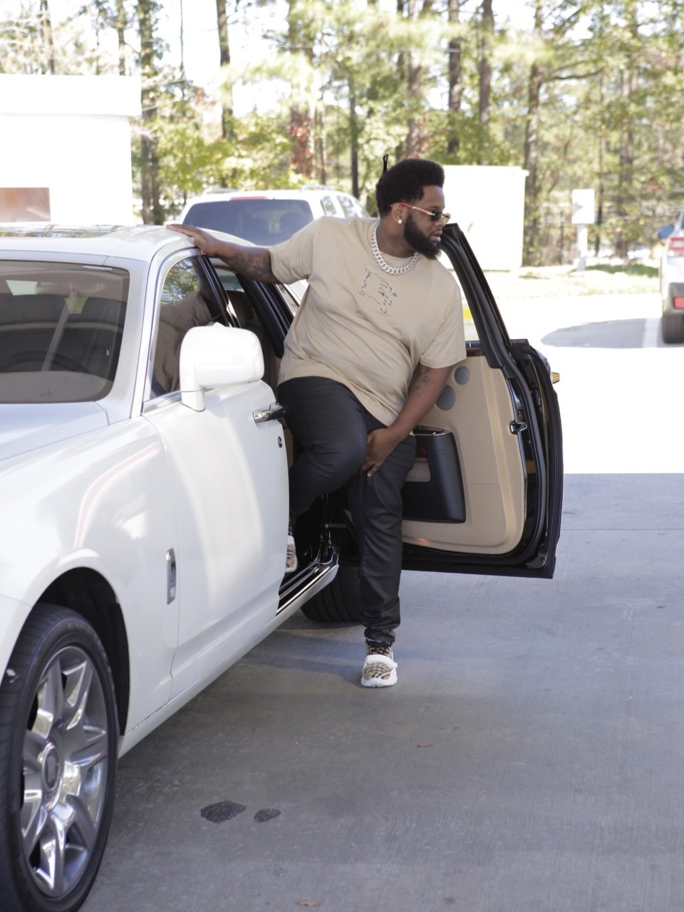 Juice The Mac stepping out of a white Rolls-Royce