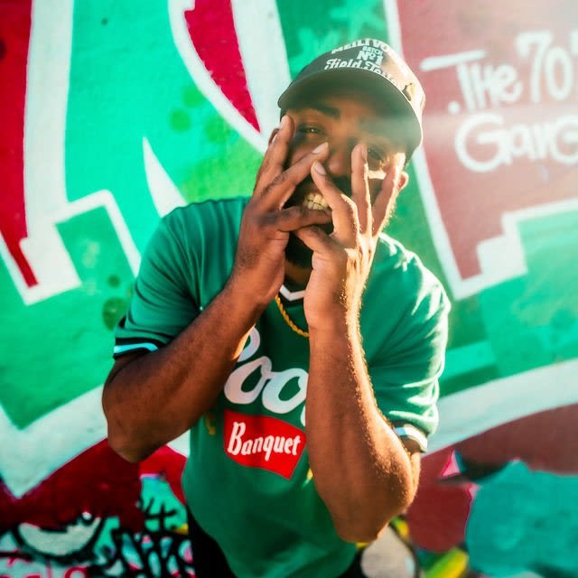 SouthSide Hippie posing in front of a colorful Austin mural