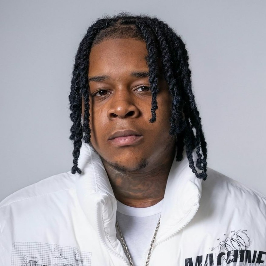 YTB Fatt in a white jacket against a gray background