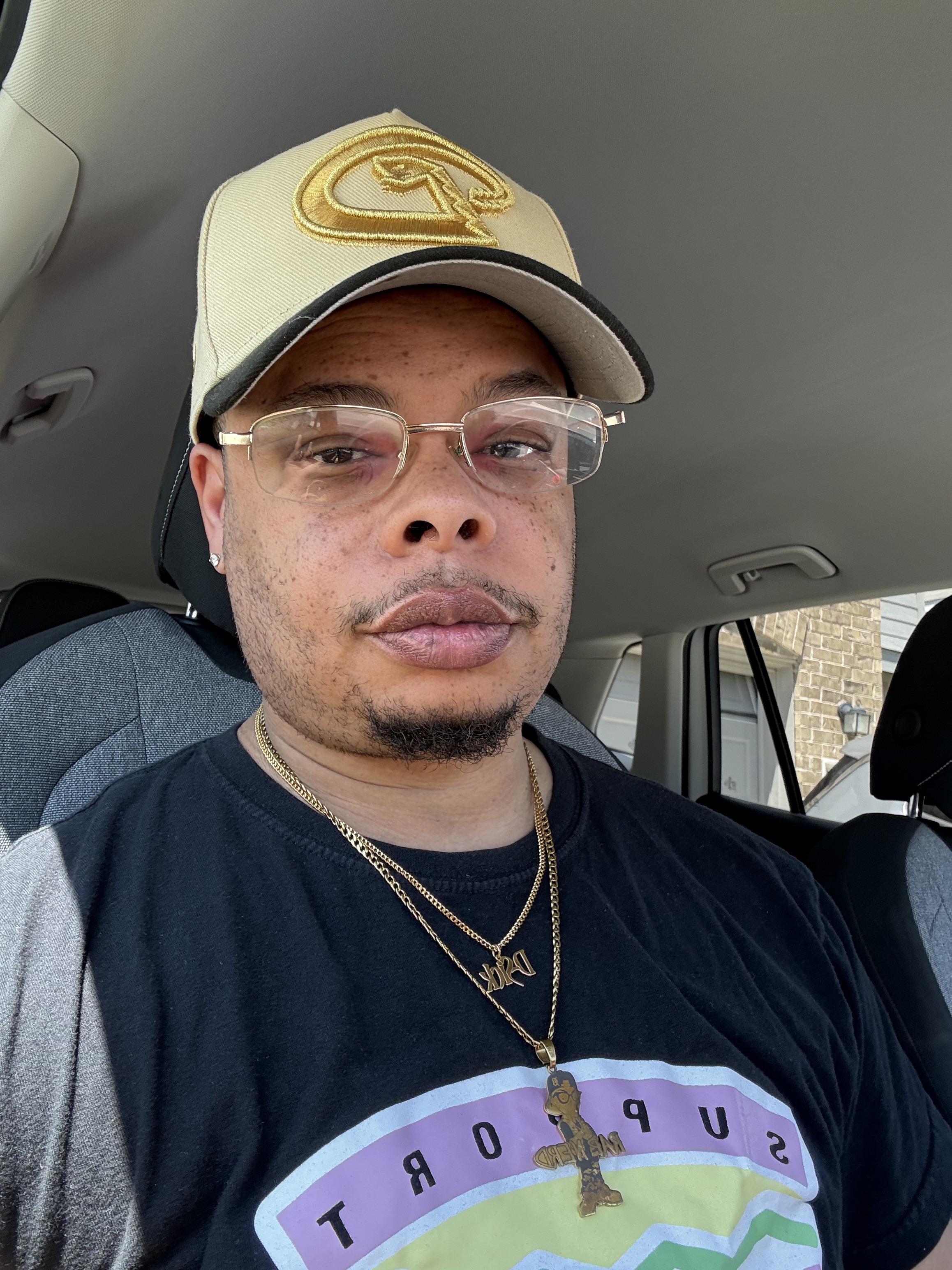 Derek D-Sick Moore wearing a cream and black cap and glasses inside a car